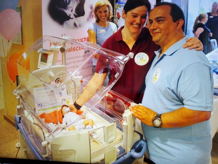 Birgit Dykstra und Bülent Önal mit Frühchenpuppe "Hannes" im Inkubator Birgit Dykstra, stv. Stationsleiterin und Bülent Önal, Vorstandsvorsitzender mit Frühchenpuppe „Hannes“ im Inkubator