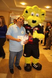 Taufe von Frühchenpuppe „Hannes“ 2 Bülent Önal mit Frühchenpuppe „Hannes“ und „Brian the Lion“, dem Maskottchen von Bayer04 Leverkusen